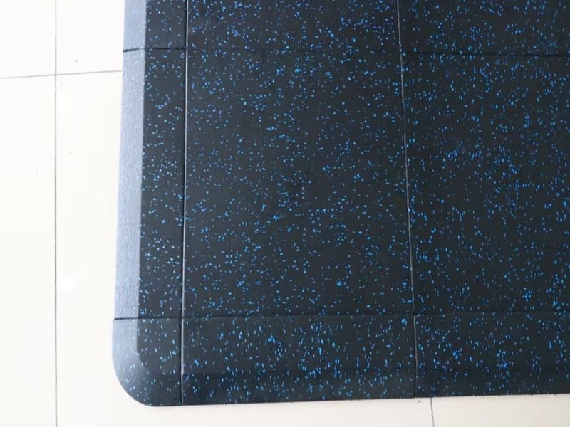 Un confronto ravvicinato di campioni di pavimentazione ginnica in gomma, schiuma EVA e vinile.